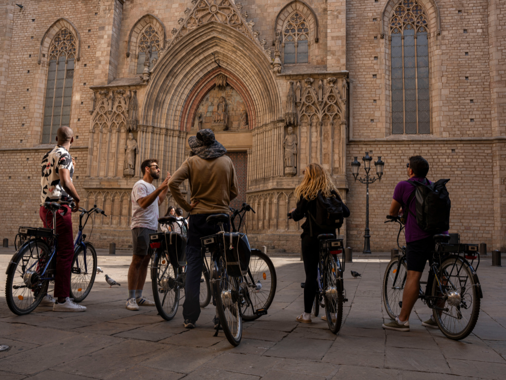 Group with bikes receiving explanations at Barcelona Cathedral.