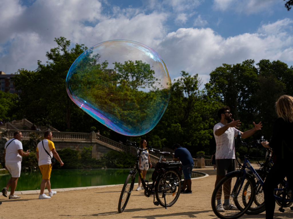 Artistic photo of a soap bubble with guide explaining bicycles around Parc de la Ciutadella fountain, Barcelona.