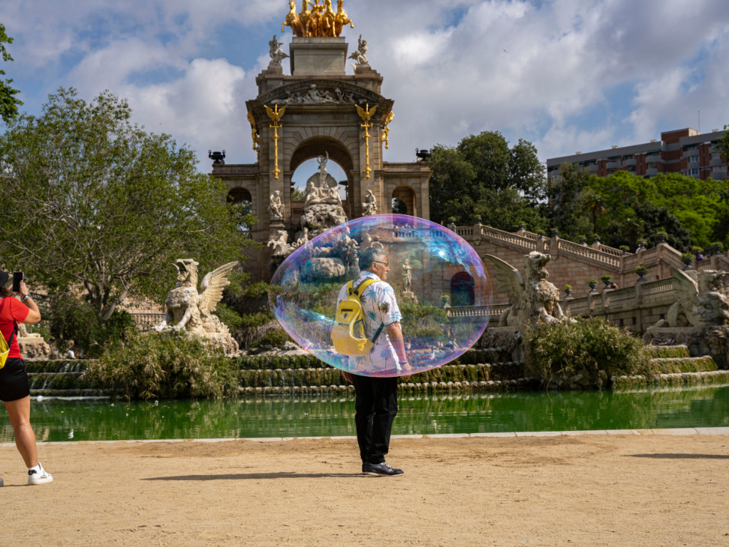 Artistic photo of a man inside a soap bubble at the fountain in Parc de la Ciutadella, Barcelona.