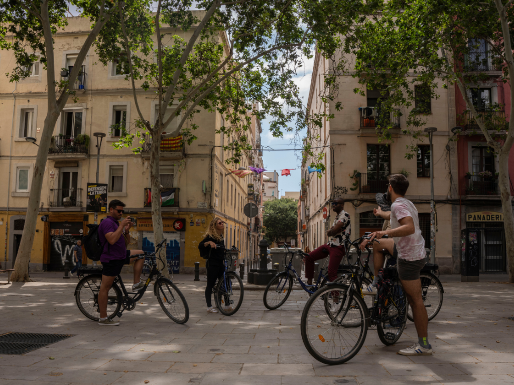 Group receiving instructions while seated on bikes in Gràcia, Barcelona.