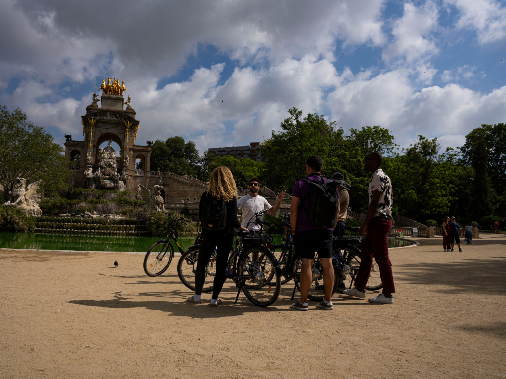 Group of cyclists listening to the guide in Parc de la Ciutadella, Barcelona.